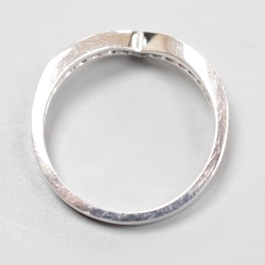 A modern 18ct white gold and channel set eleven stone diamond chip set herringbone shaped ring, size M, gross weight 3.6 grams